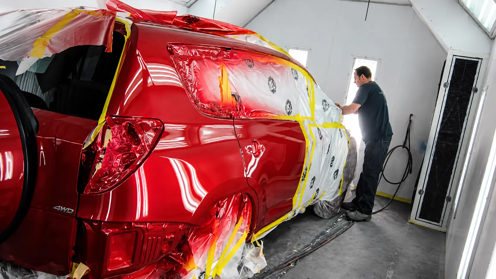 Freshly painted red SUV in the paint booth