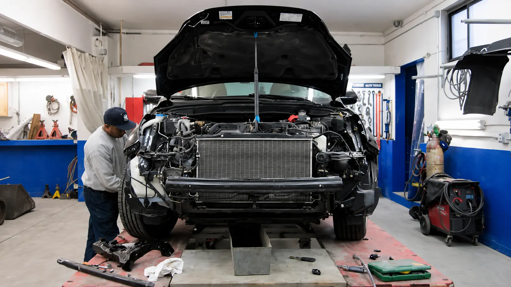 Technician performing structural collision repair on a vehicle at Chalkstone Auto Body