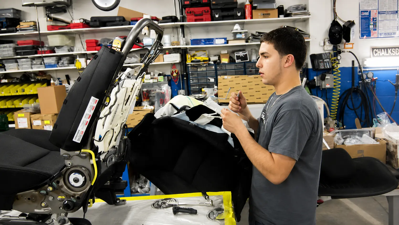 Technician reassembling a vehicle interior seat